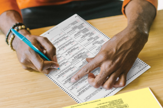 Voter sitting at a desk filling out a ballot