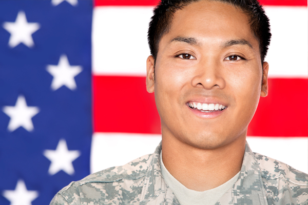 Serviceman standing in front of an American flag