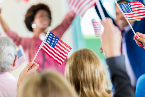 Woman candidate interacting with enthusiastic supporters holding flags